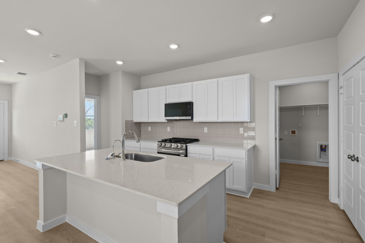 A kitchen with white cabinets.