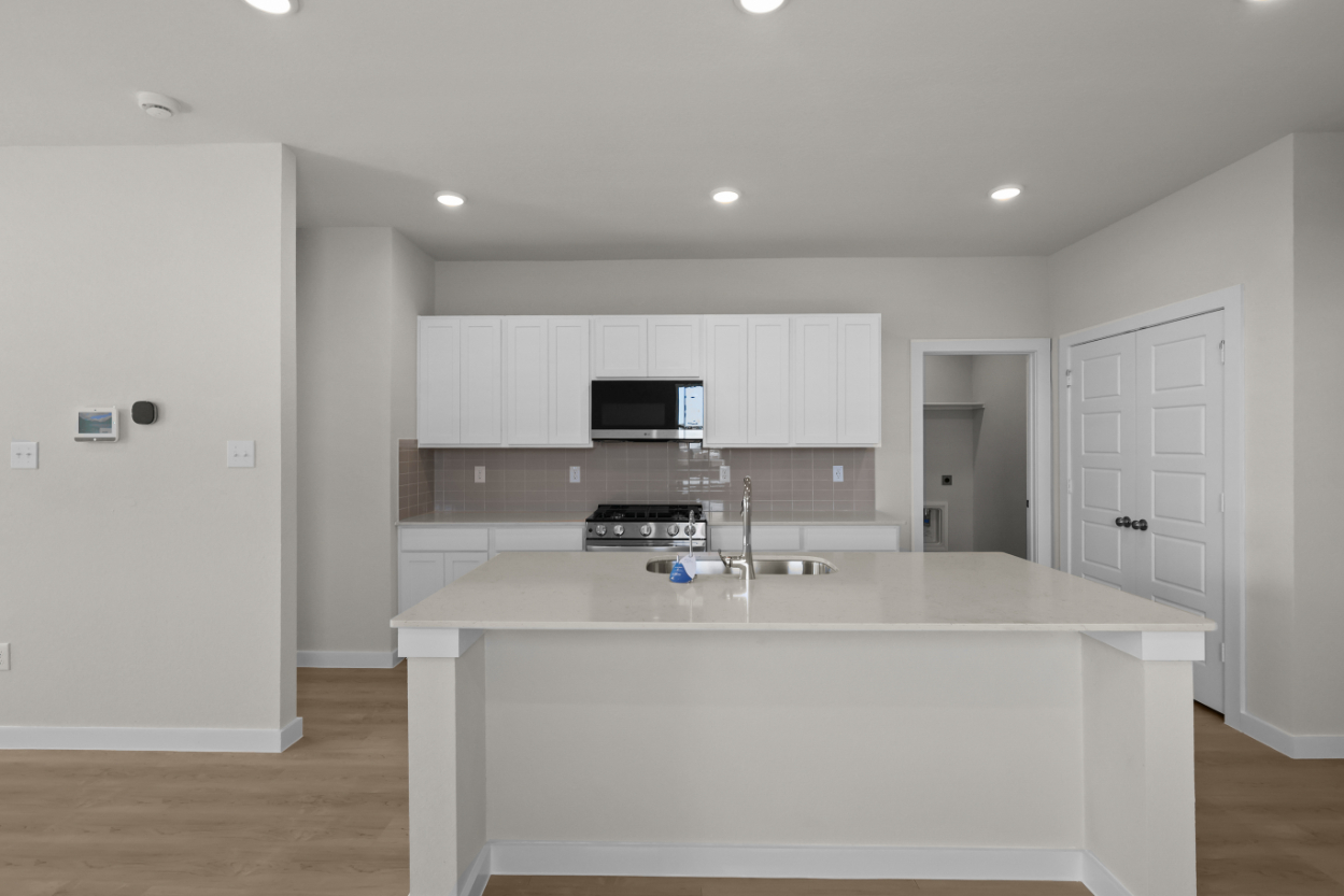 A kitchen with white cabinets.