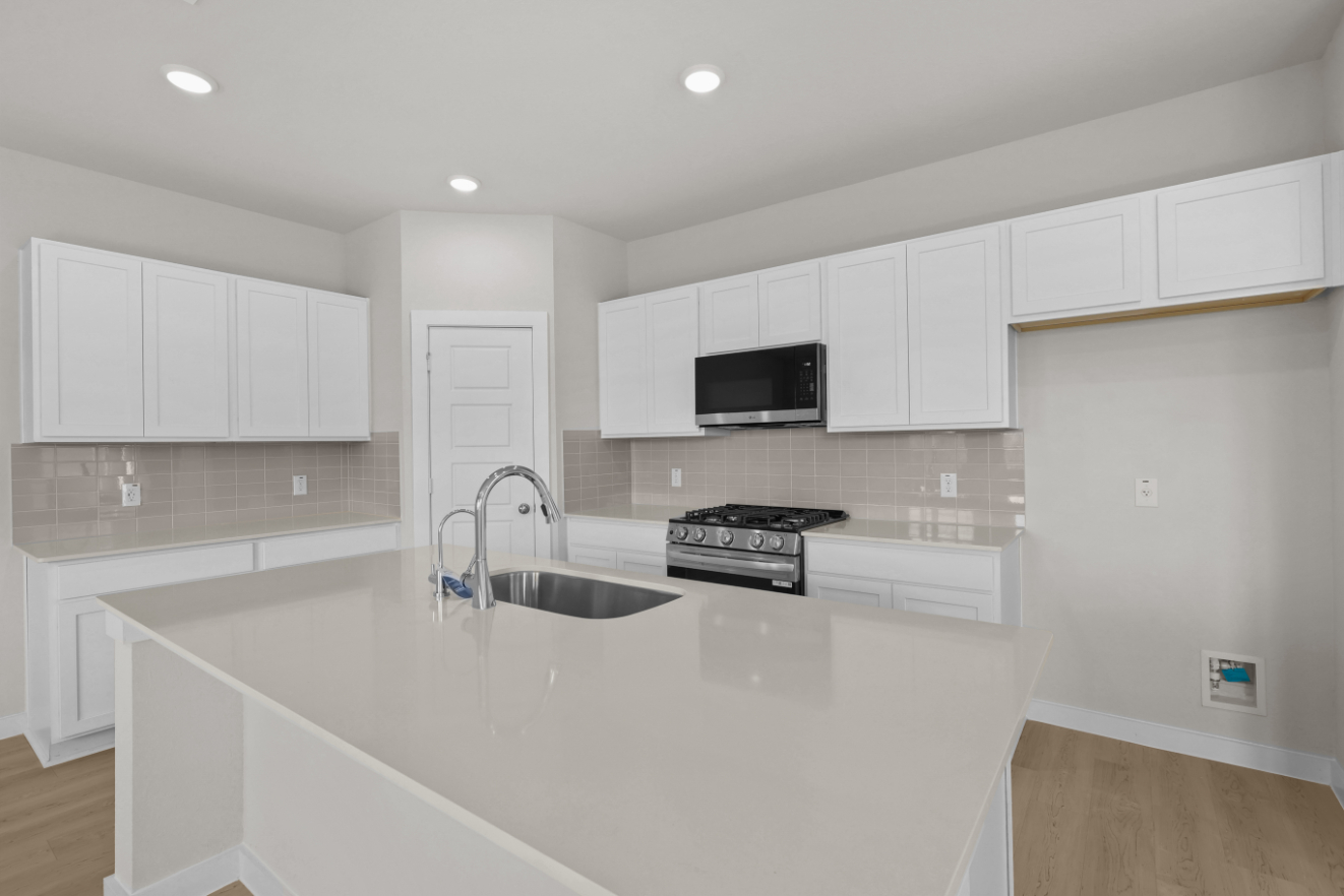 A kitchen with white cabinets.