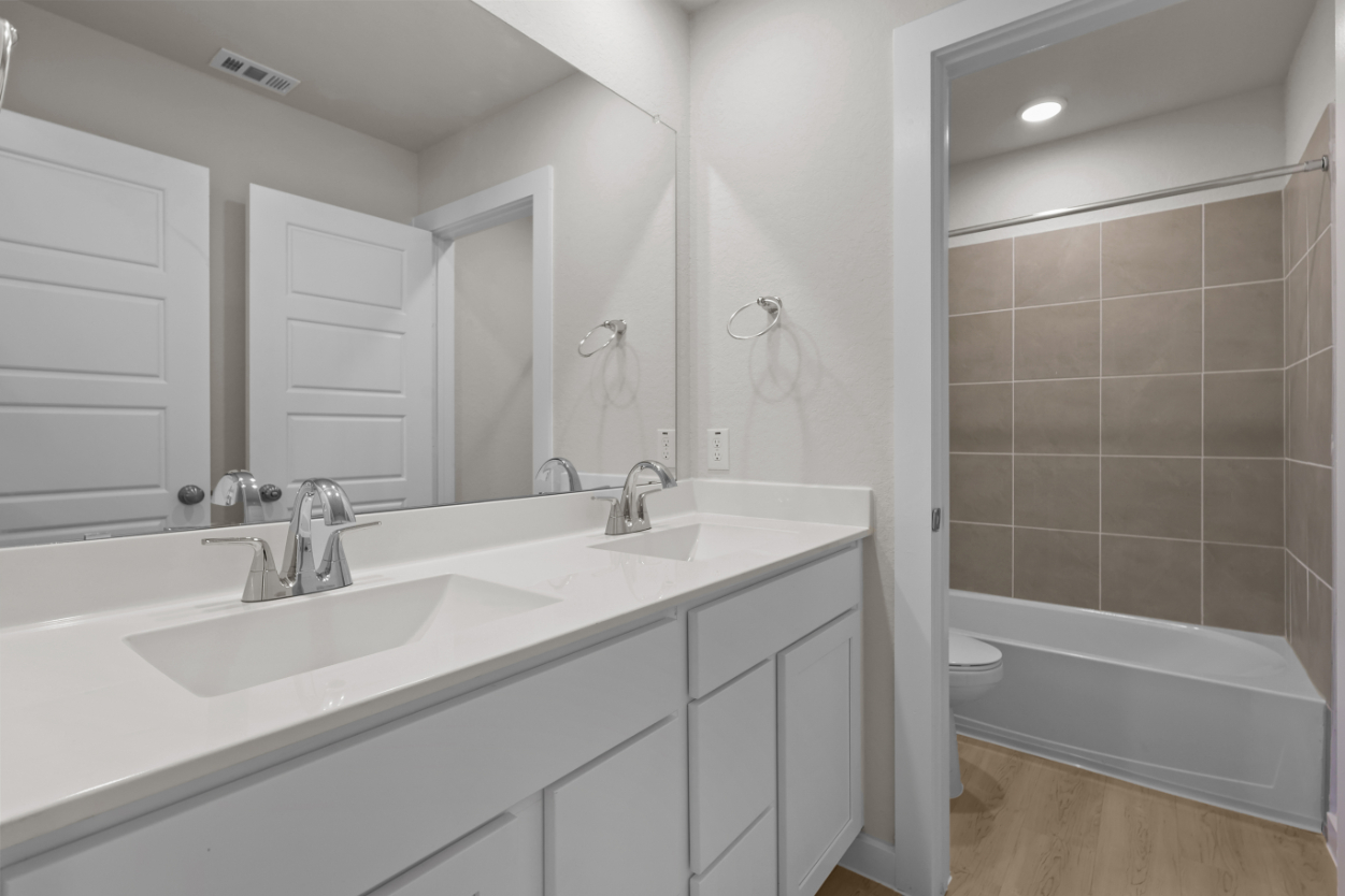 A bathroom with a tub sink and toilet.