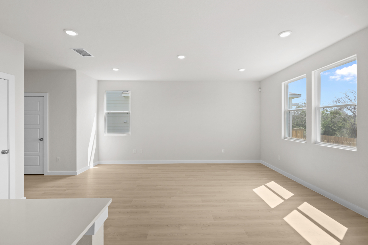 A room with a wood floor and windows.