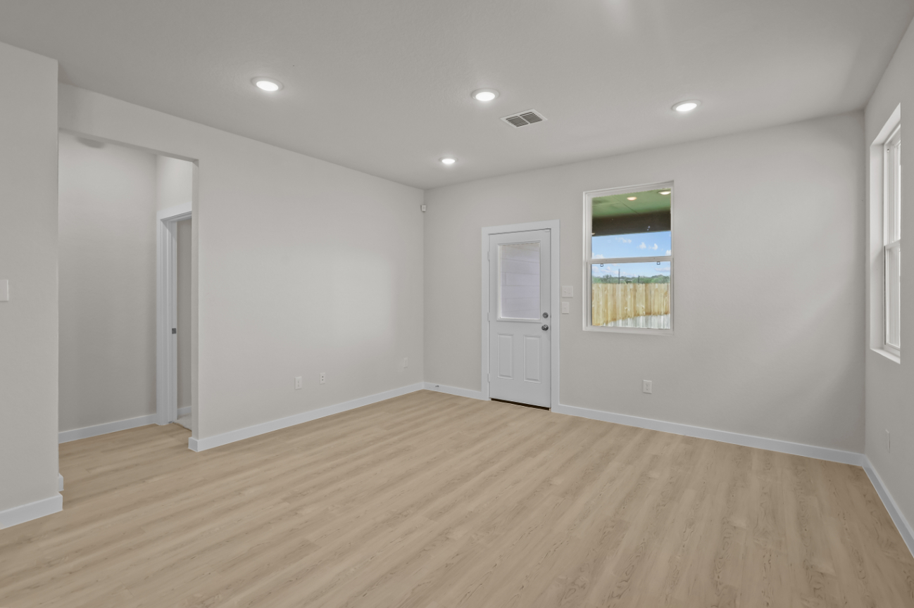 A room with white walls and a wood floor.