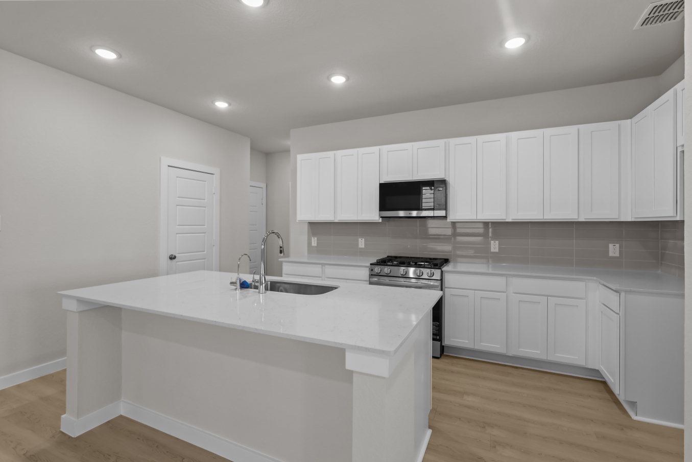 A kitchen with white cabinets.