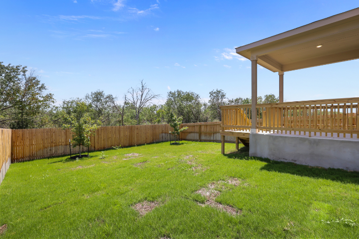 A fenced in yard with a covered area and a wood structure.