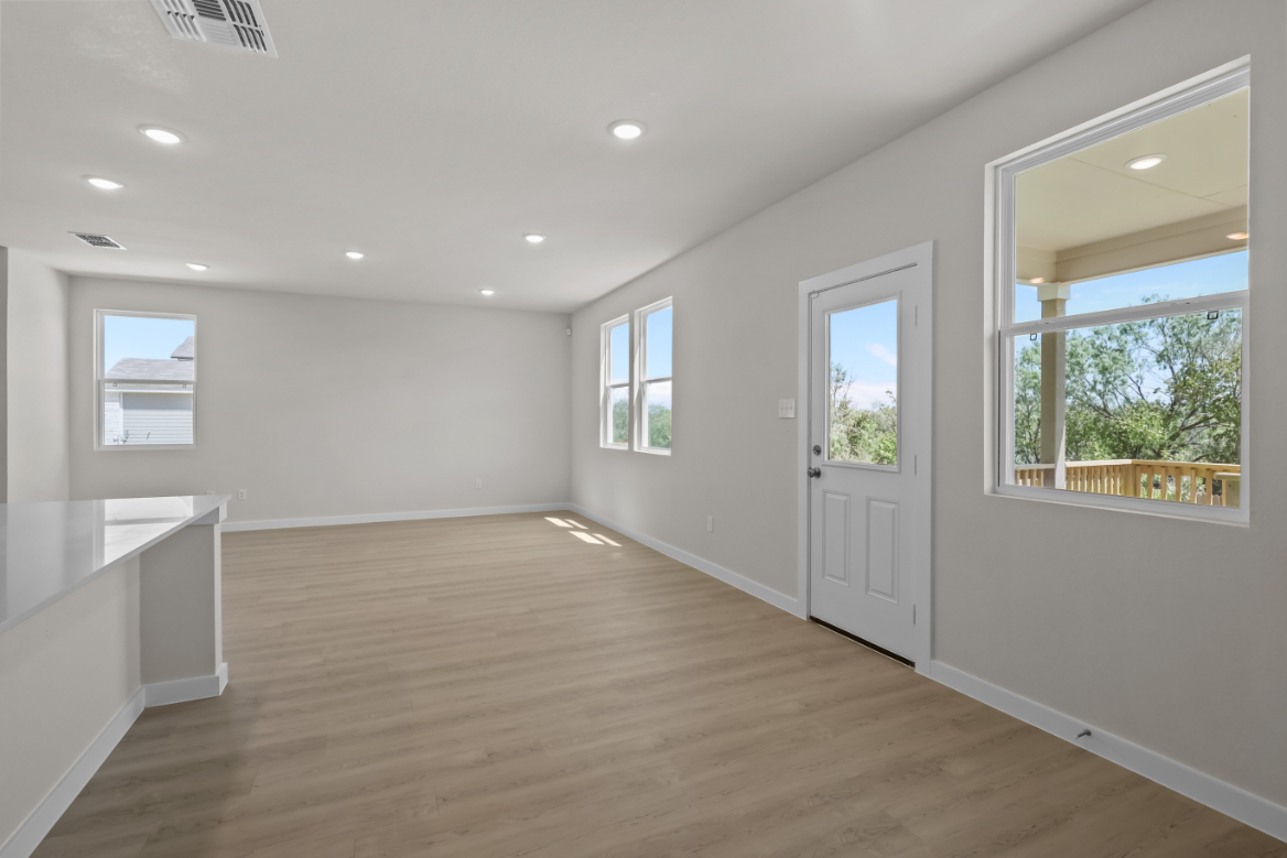 A room with a wood floor and windows.