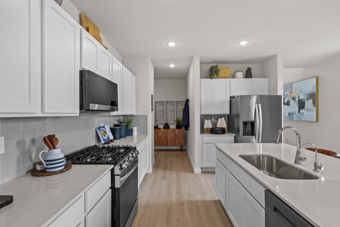 A kitchen with white cabinets.