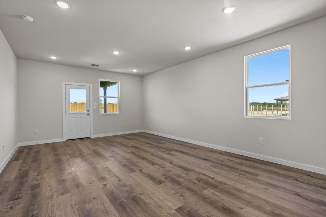 A room with a wood floor and windows.