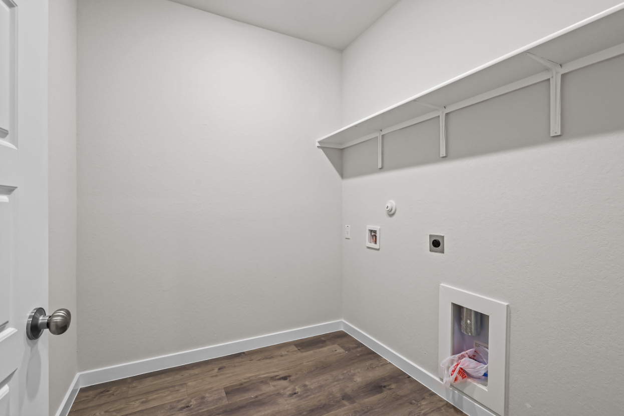 A white room with a wood floor and white walls.