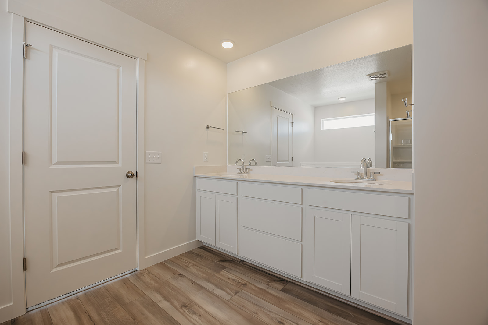 A bathroom with white cabinets.
