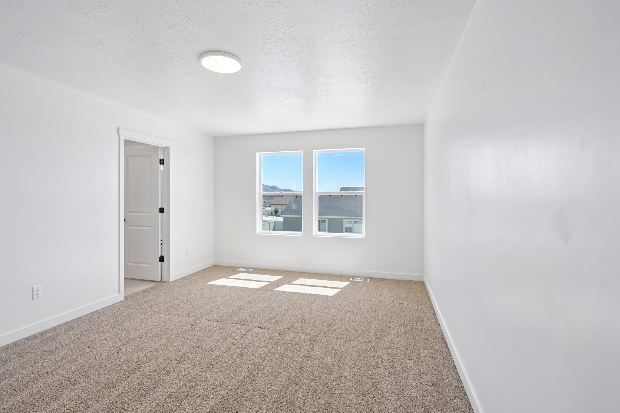 A room with a carpet and a window.