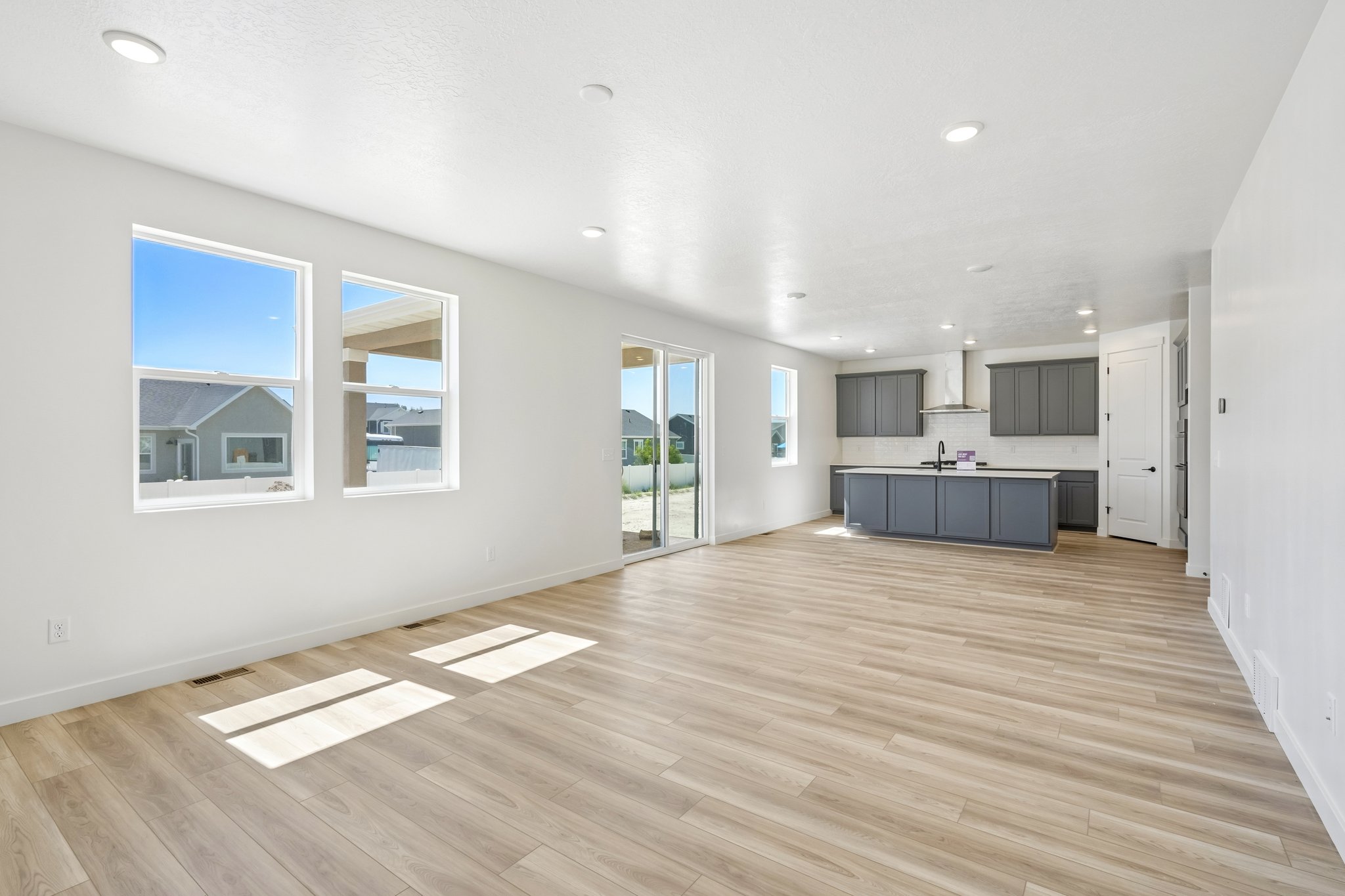 A large empty room with a wood floor and white walls.