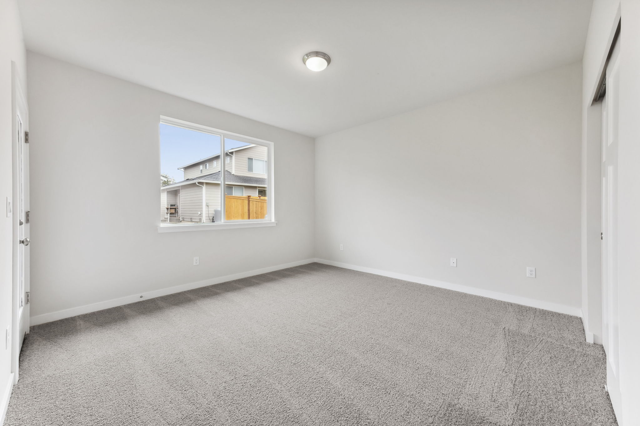 A room with a window and a carpet.
