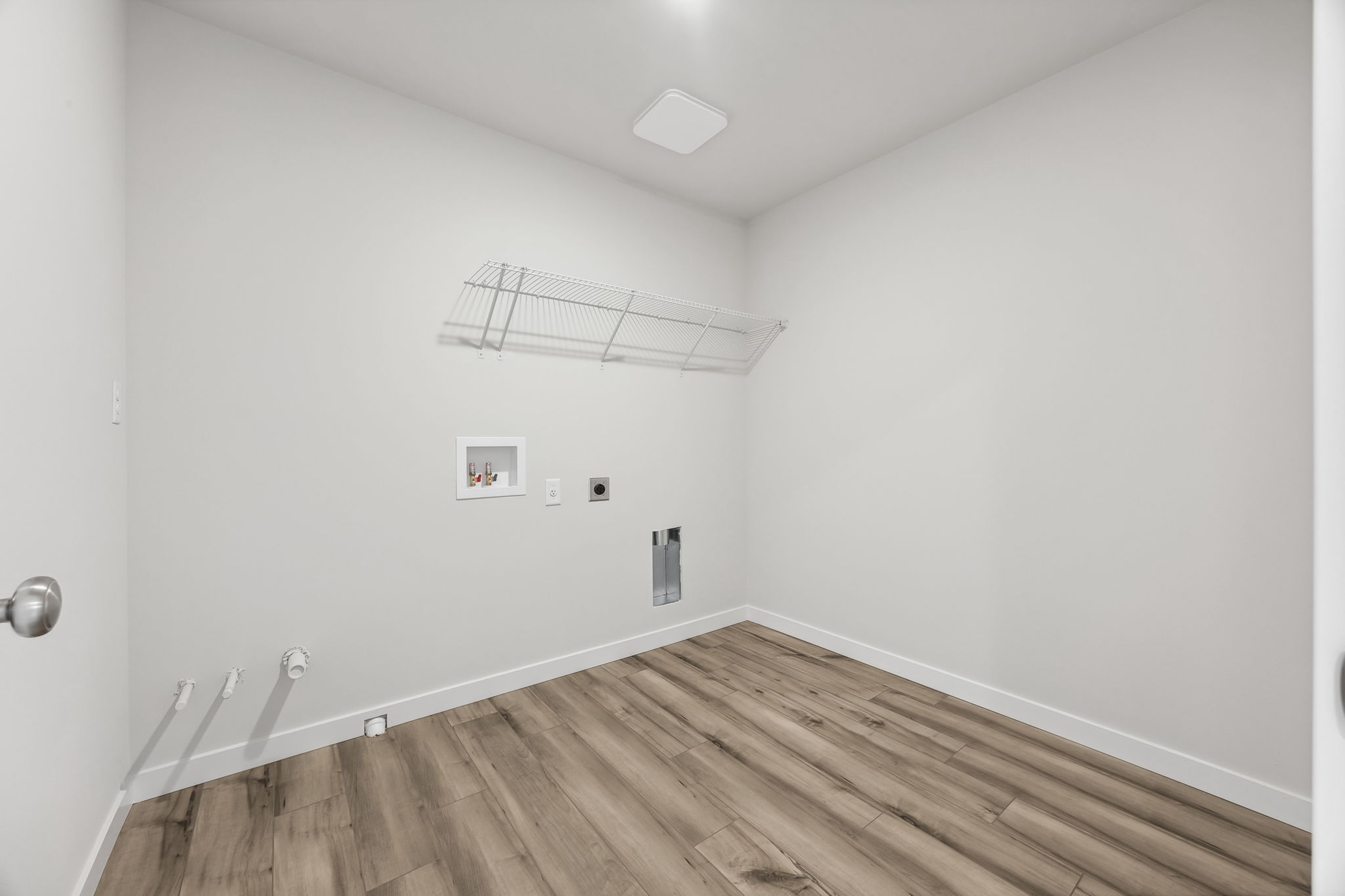 A room with a wood floor and white walls.