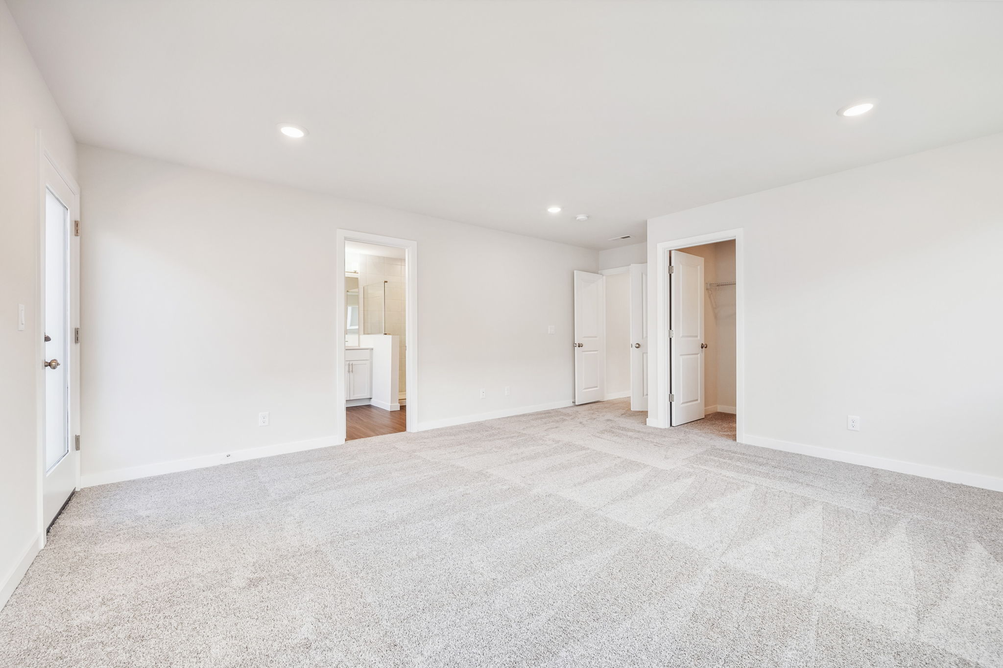 A long hallway with white doors.