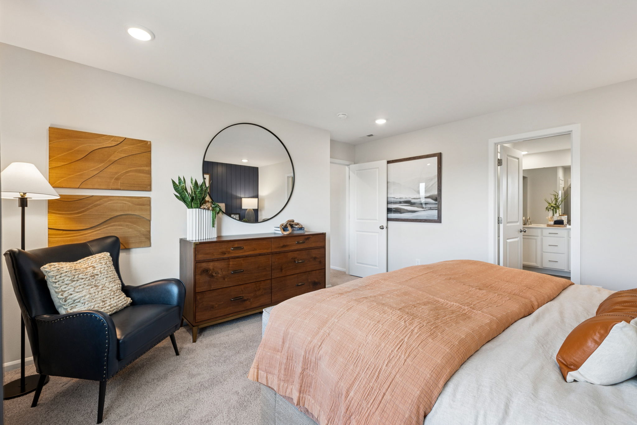 A bedroom with a bed and a chair.