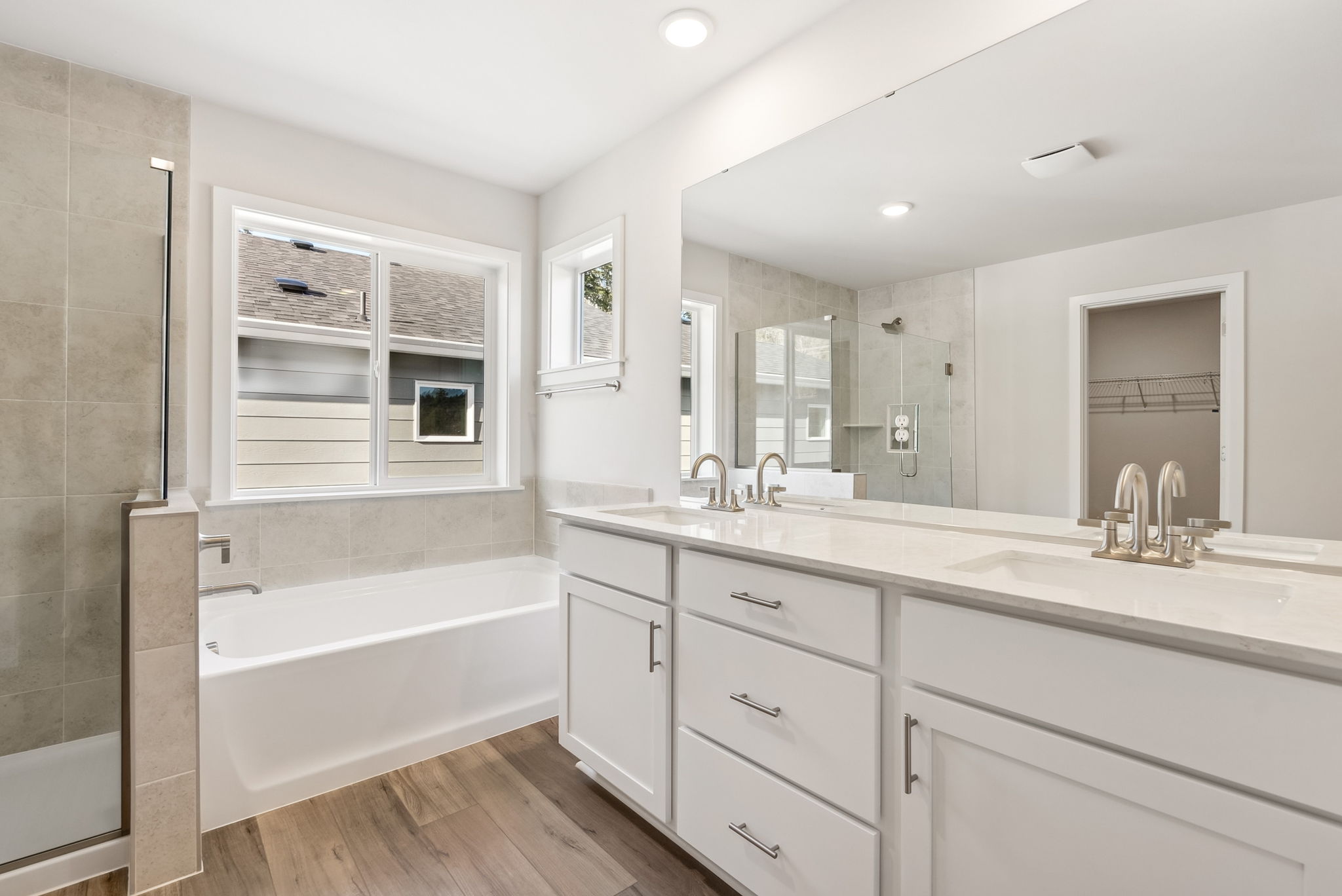 A bathroom with a tub sink and cabinets.