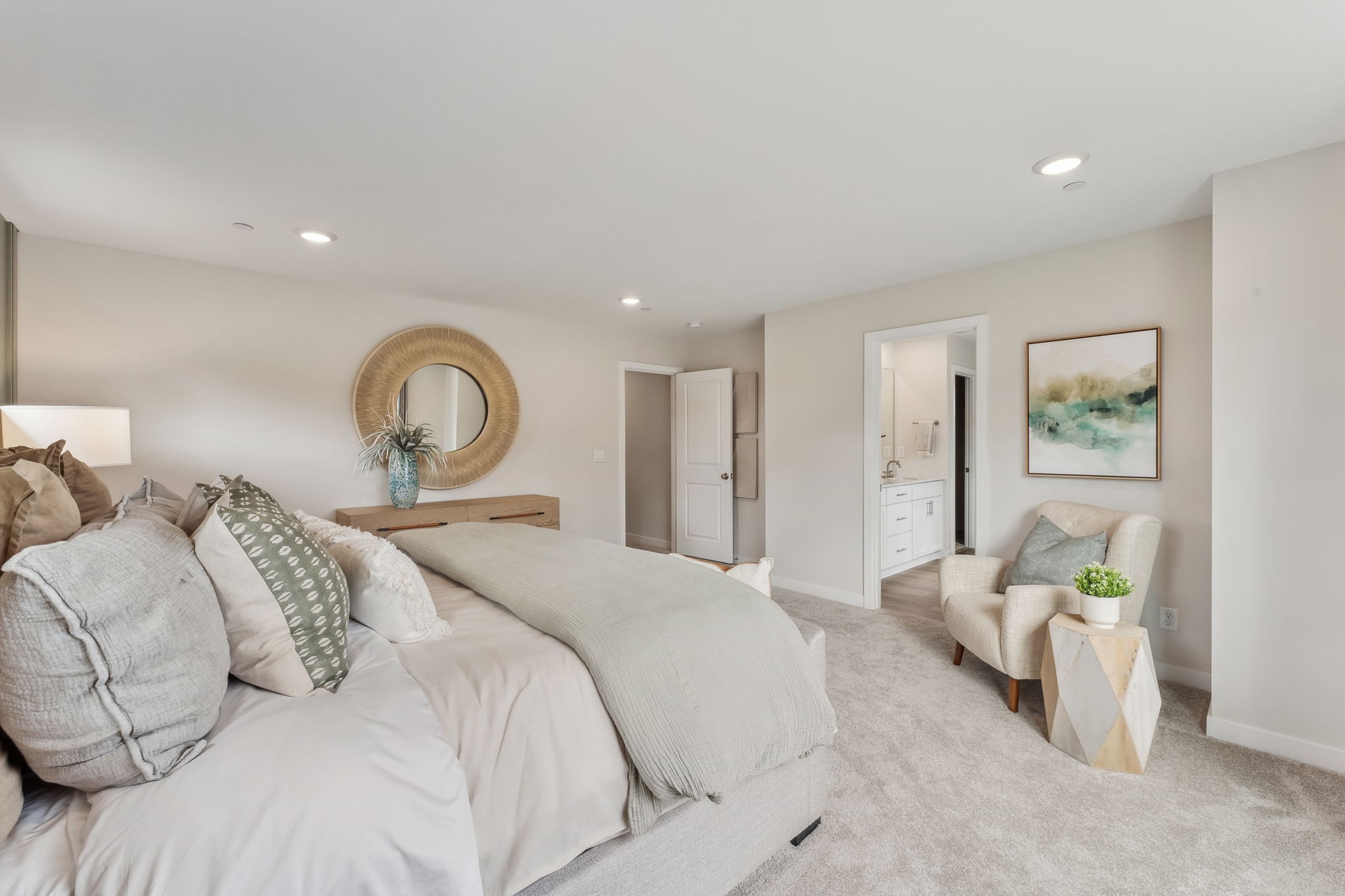A large bedroom with a bed and a chair.