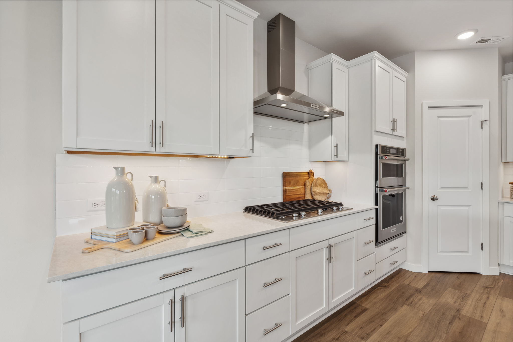 A kitchen with white cabinets.