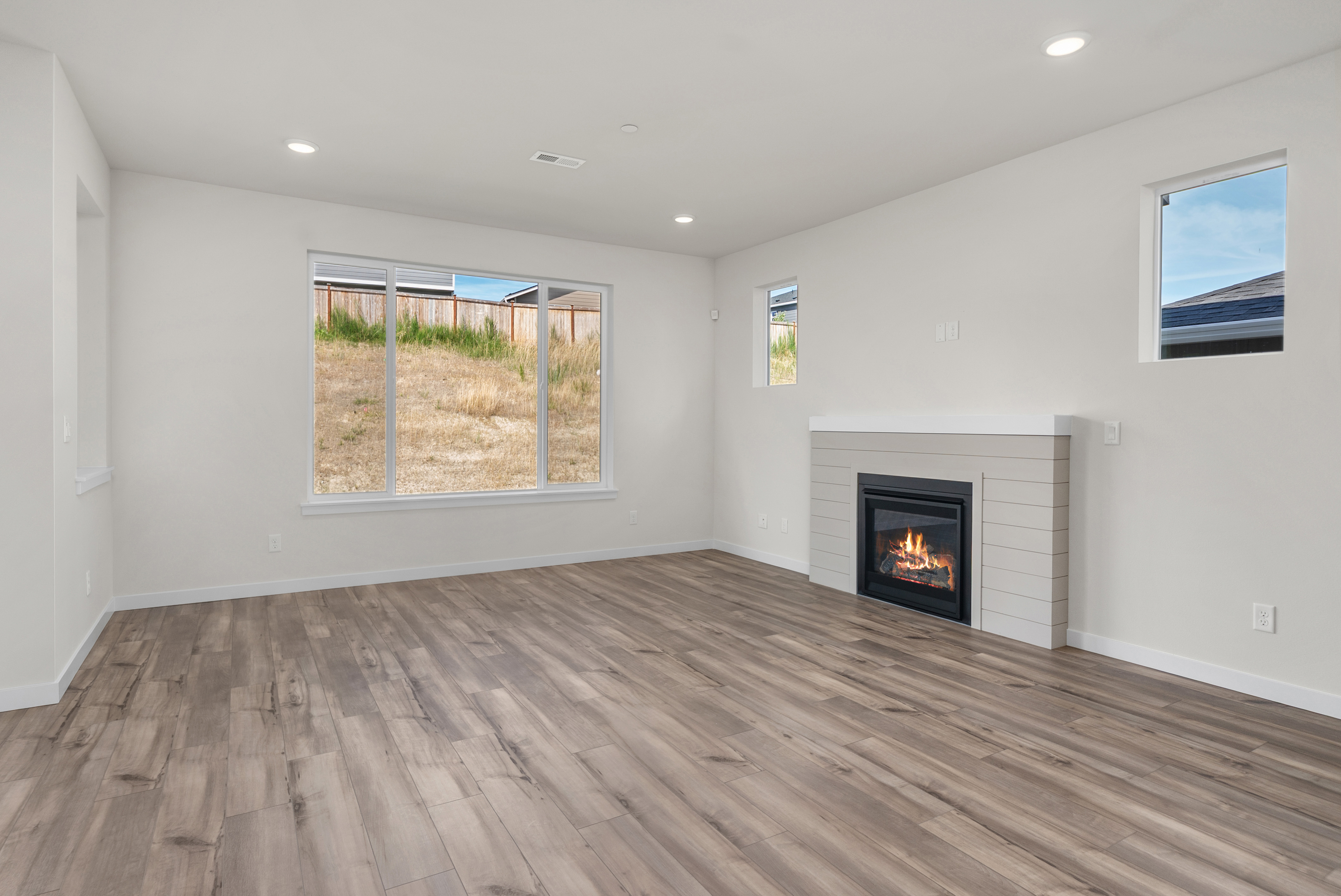 A room with a fireplace and a wood floor.