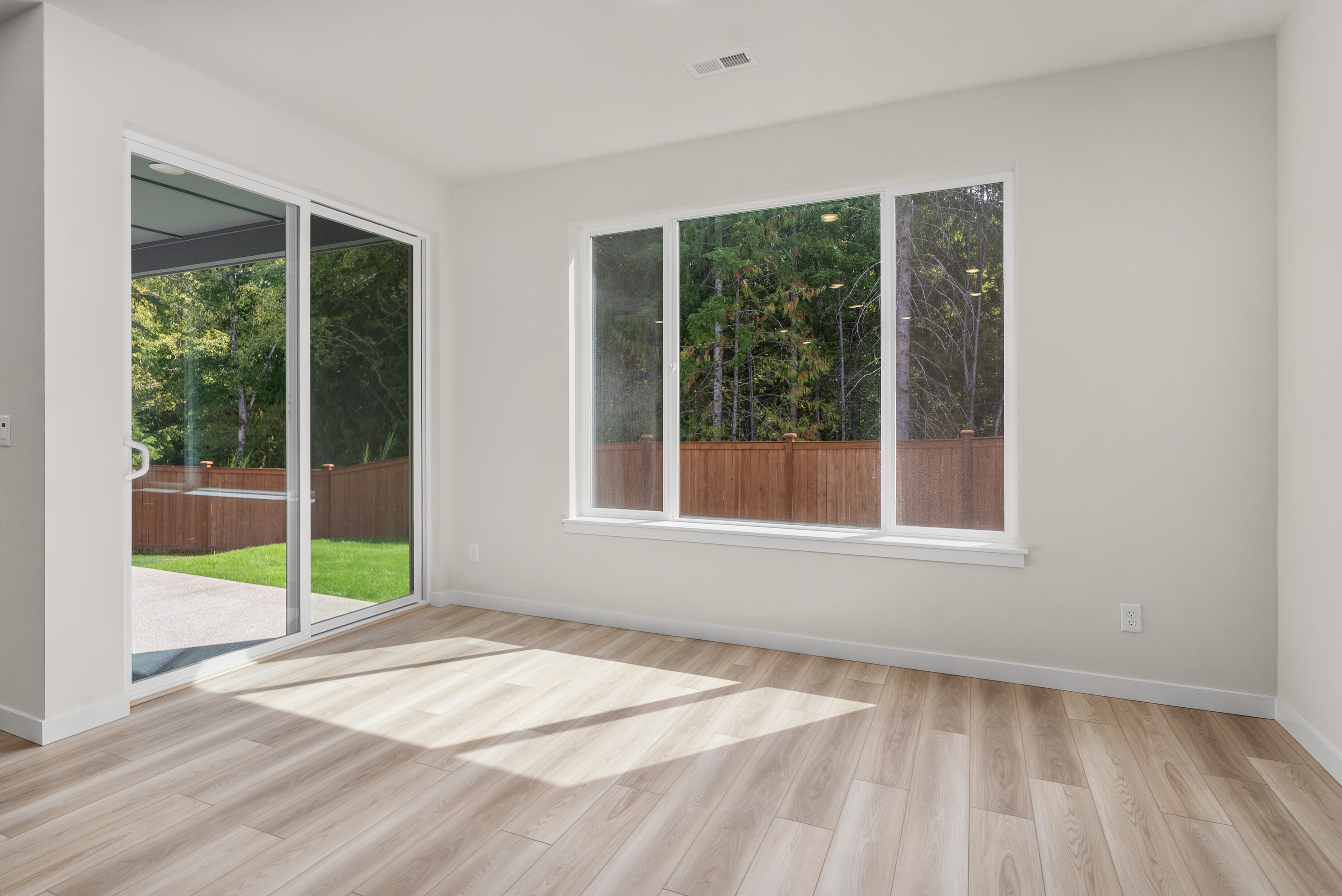 A room with a wood floor and windows.