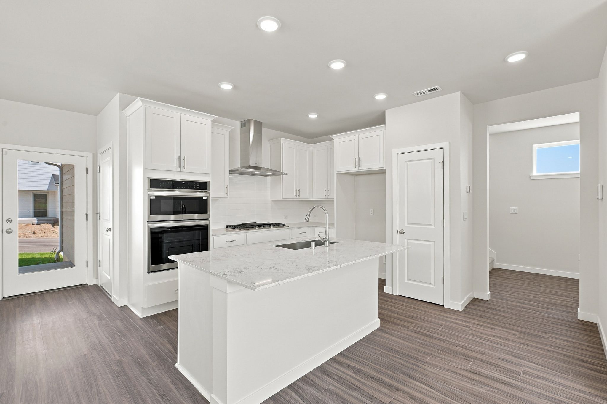 A kitchen with white cabinets.
