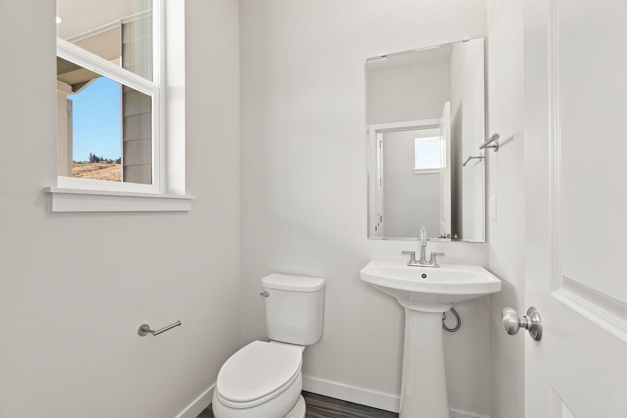 A bathroom with a sink toilet and mirror.