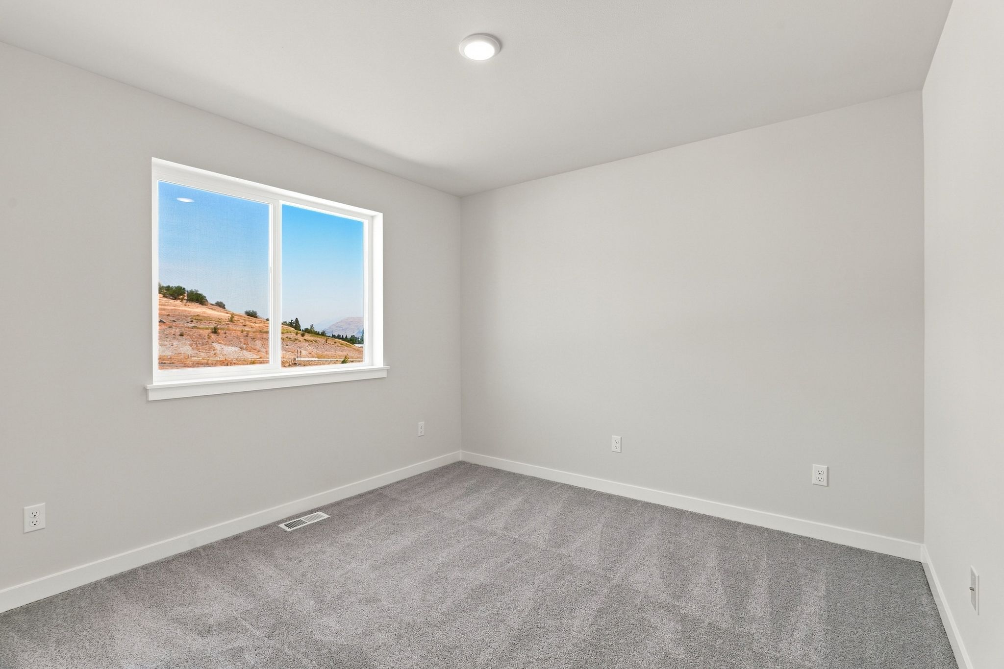 A room with a window and a carpet.