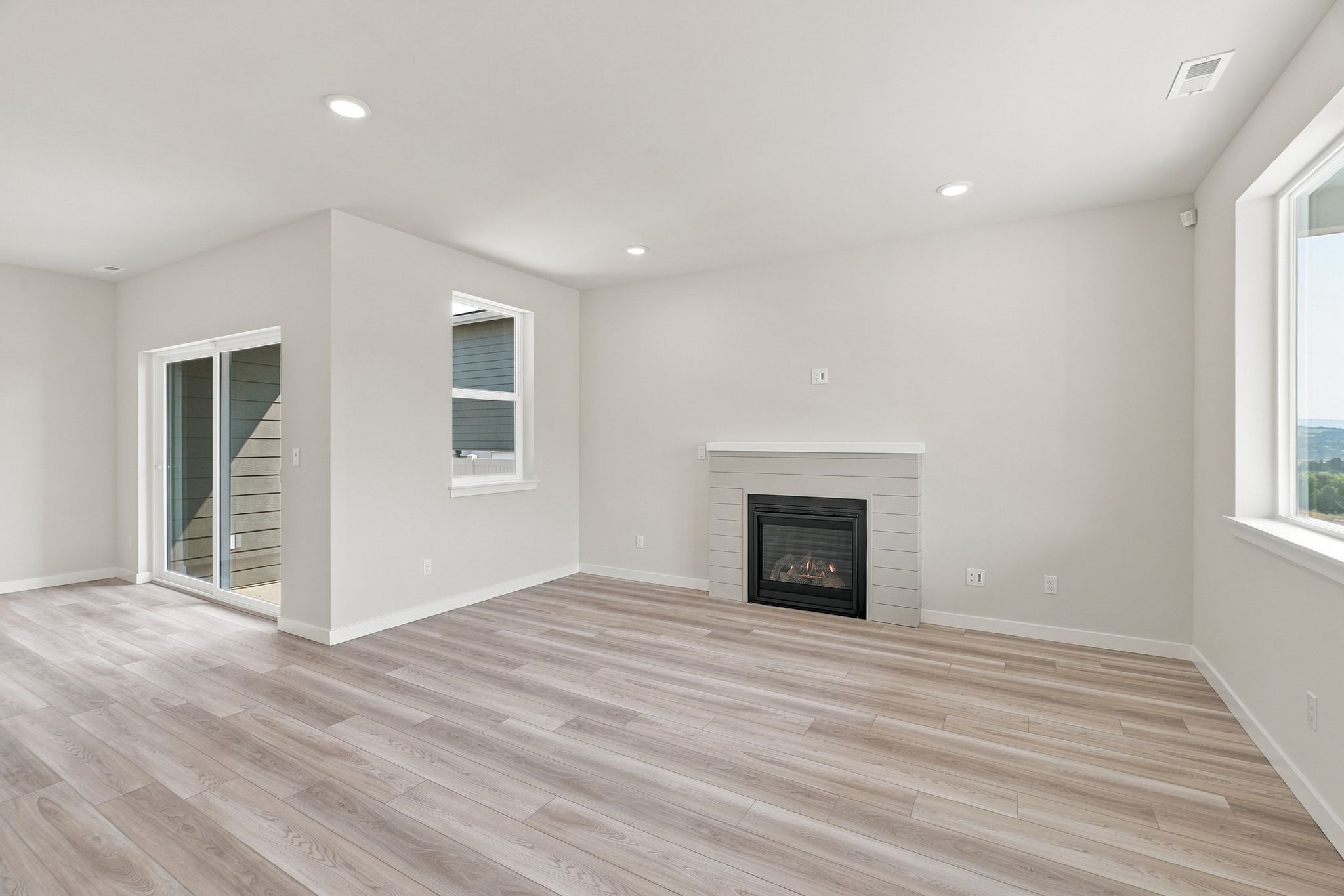 A room with a fireplace and wood floors.