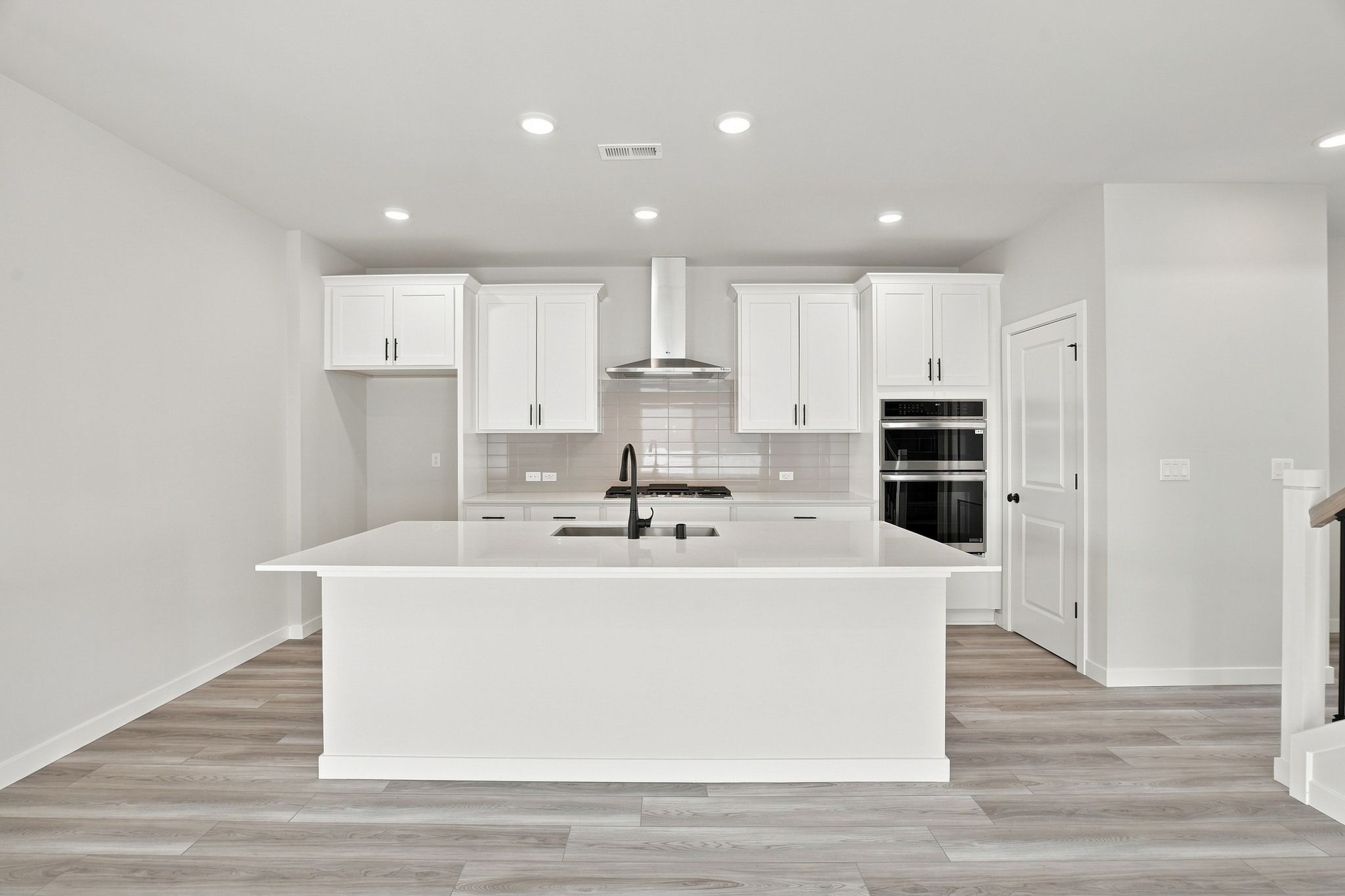 A large white kitchen with a large white countertop.