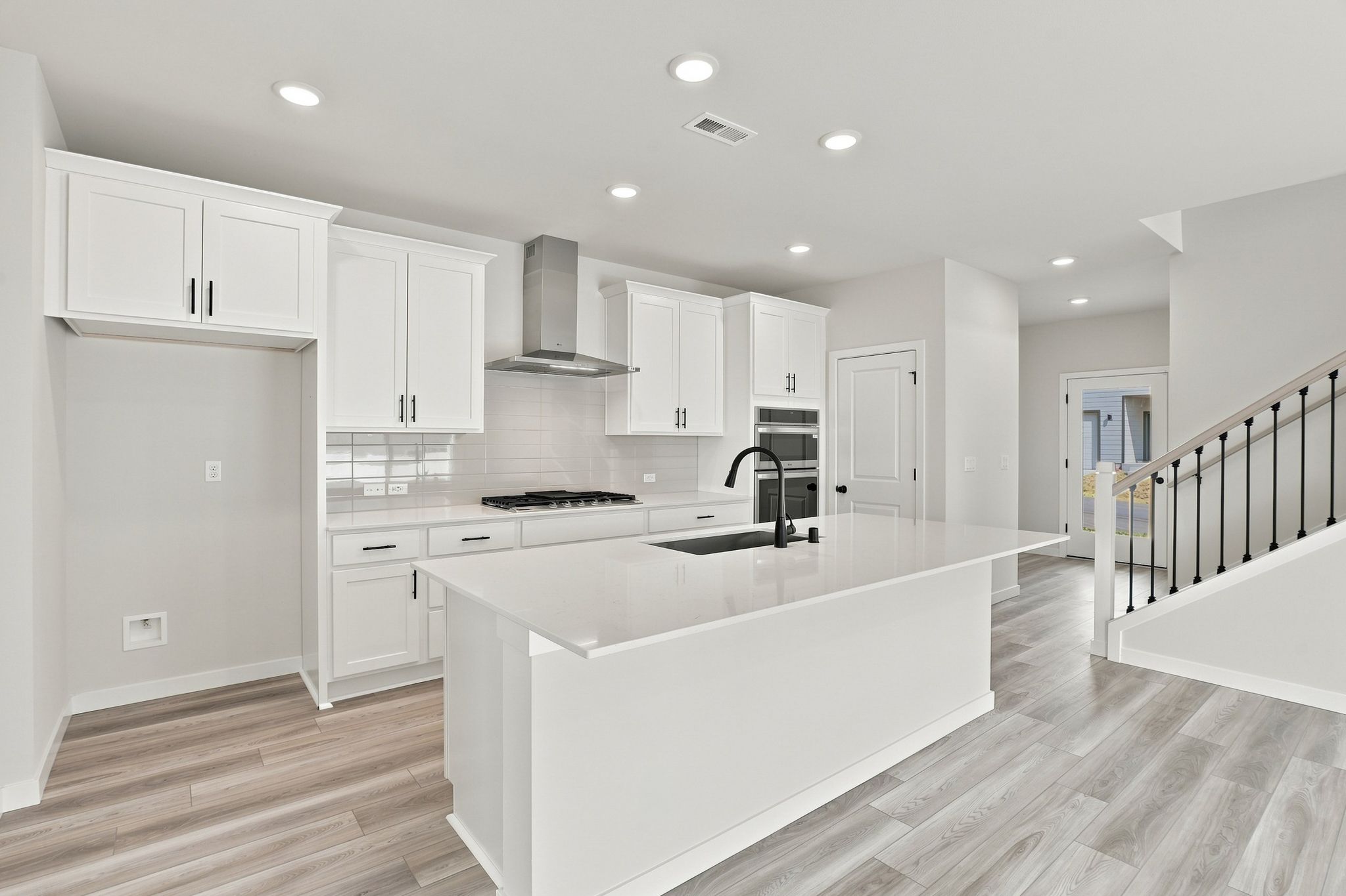 A kitchen with white cabinets.