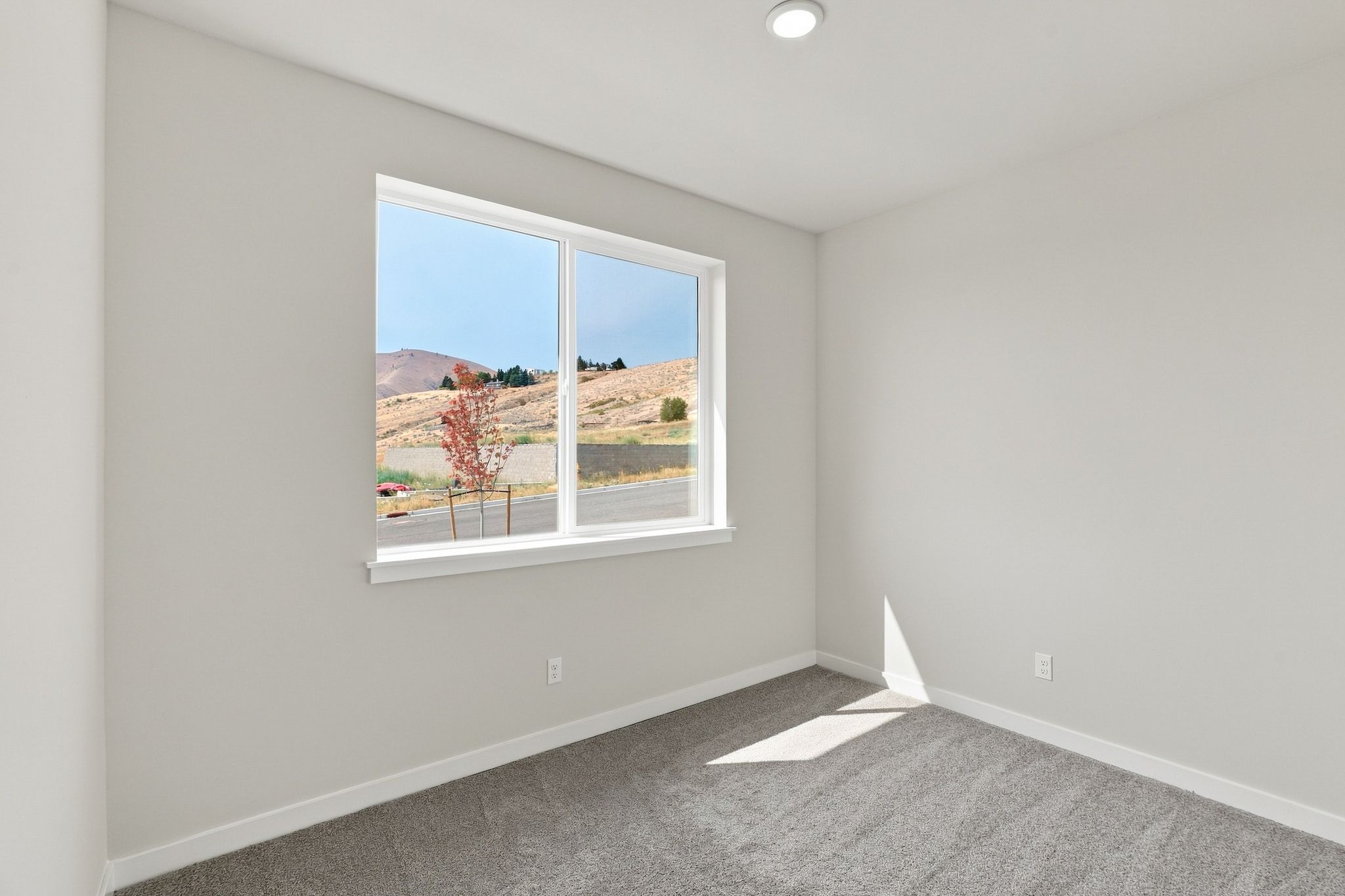 A room with a window and a view of a city.
