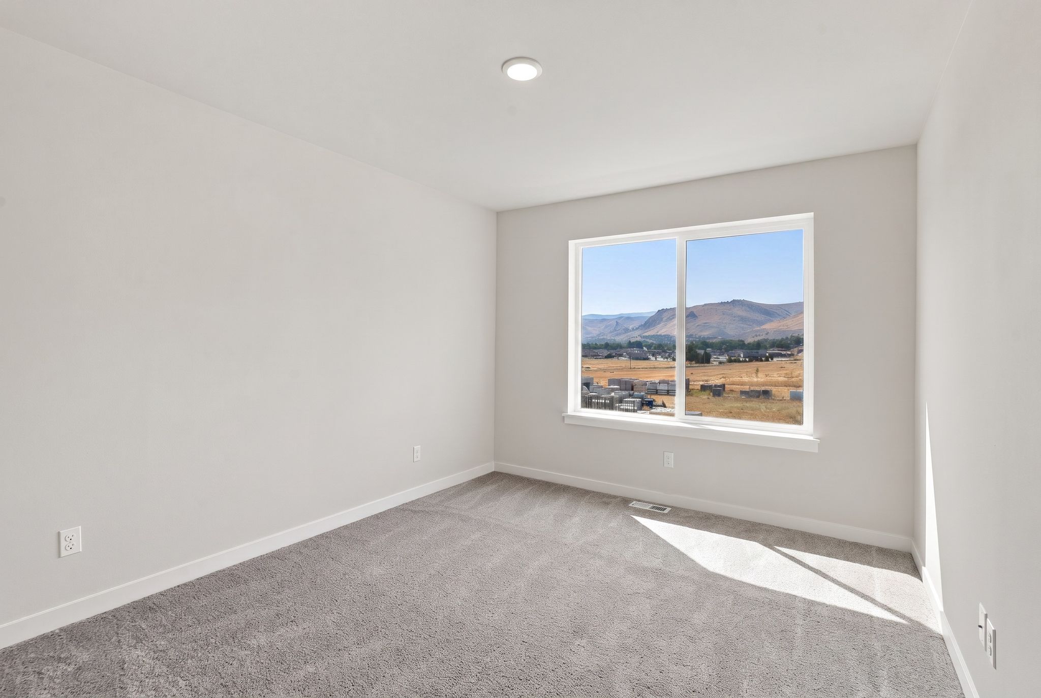 A room with a window and a view of a city.