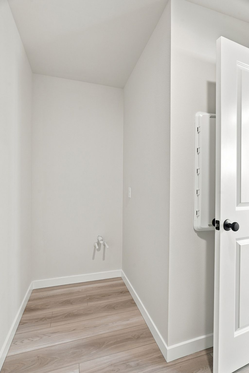 A white room with a wood floor.