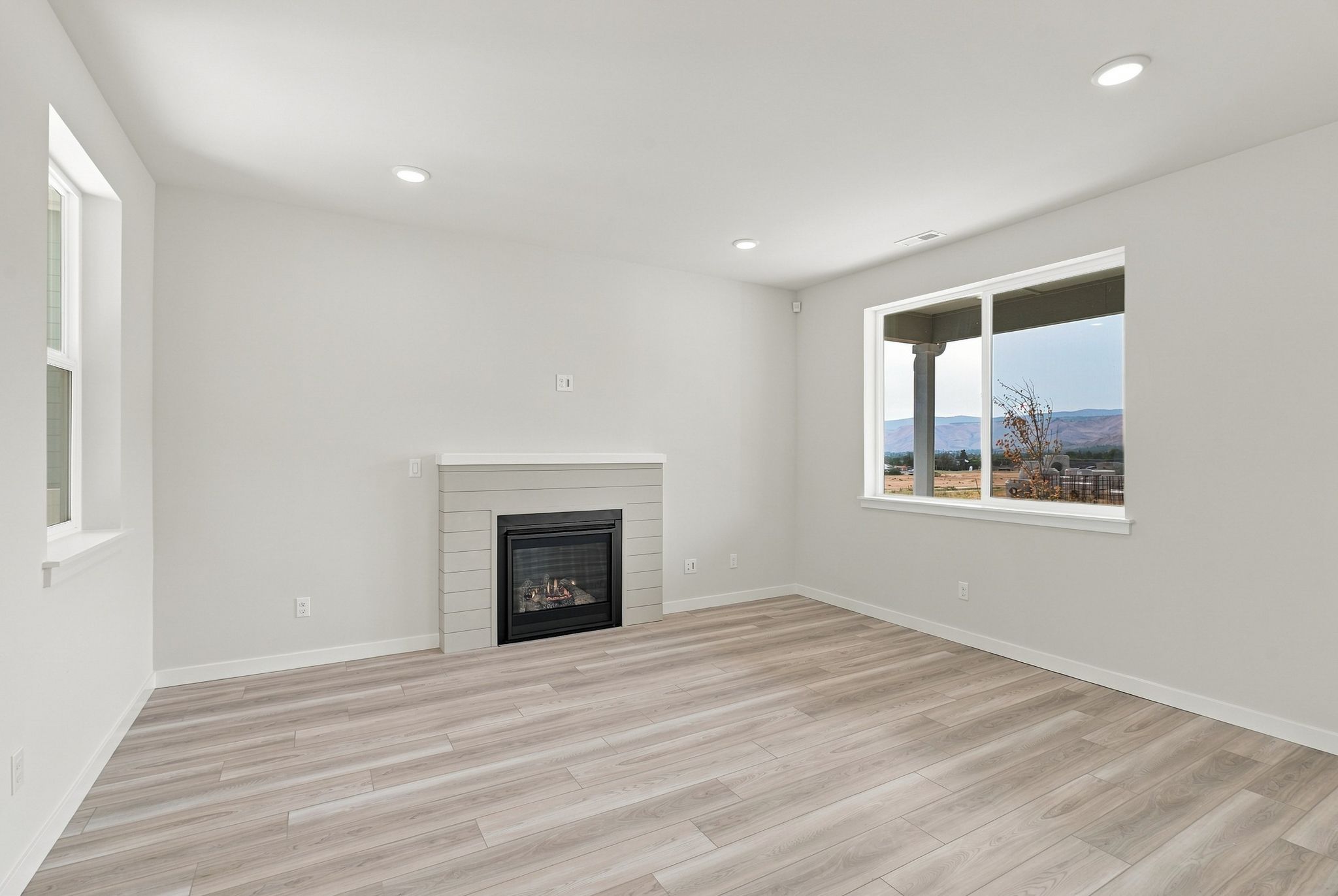 A room with a fireplace and a wood floor.