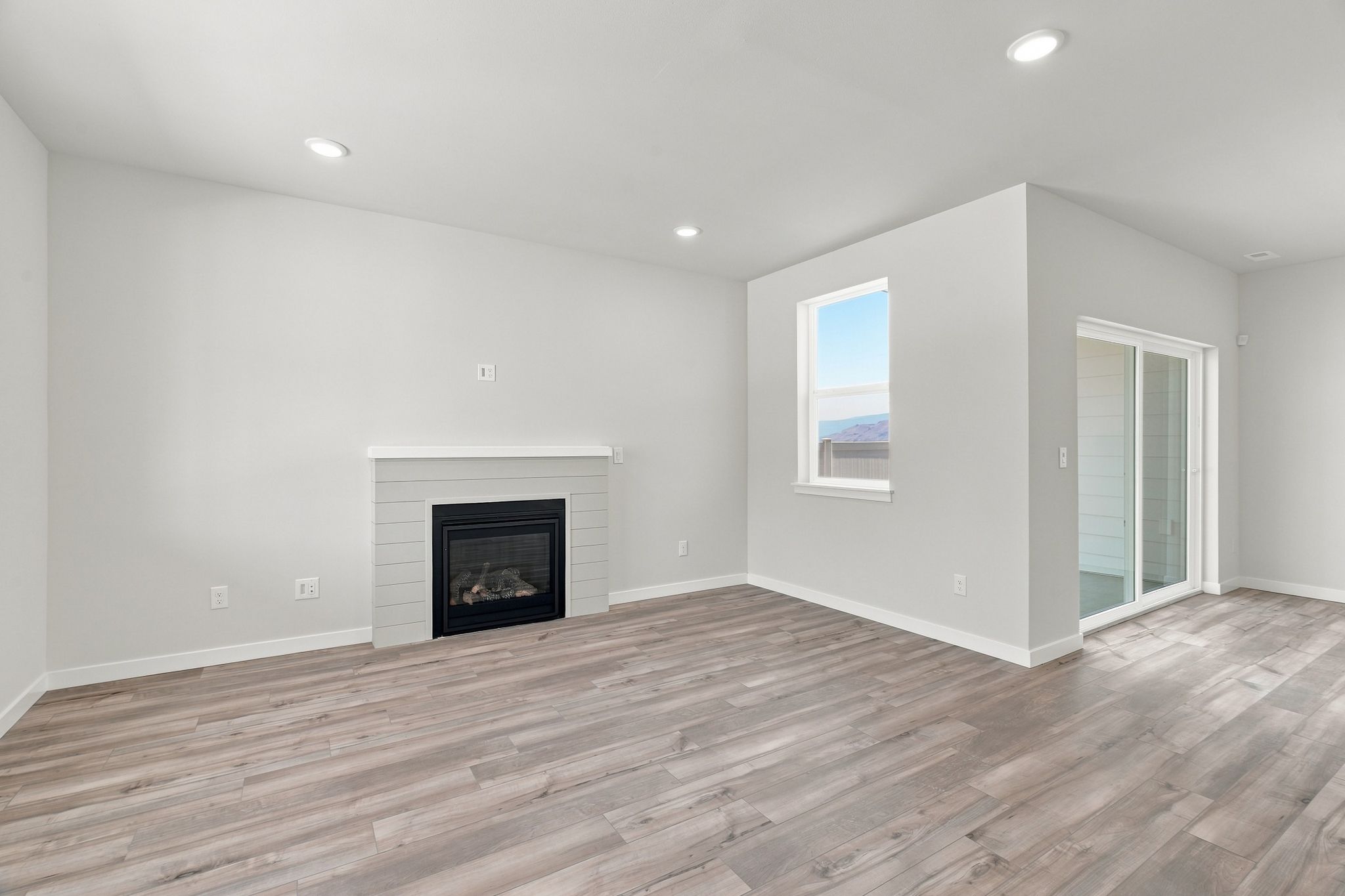 A room with a fireplace and wood floors.