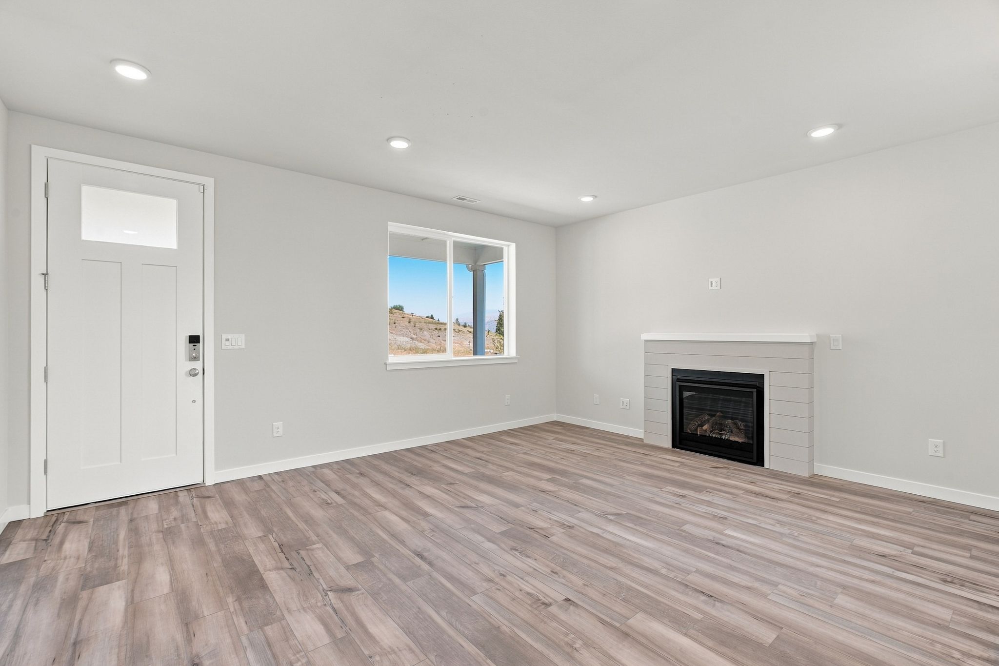 A room with a fireplace and a wood floor.