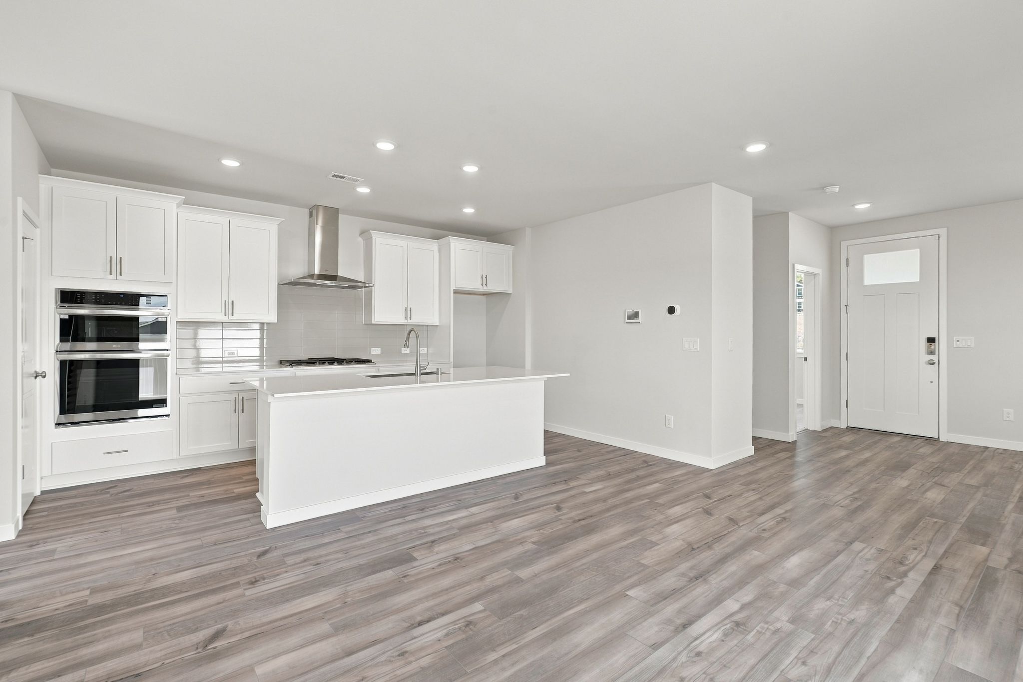 A kitchen with white cabinets.