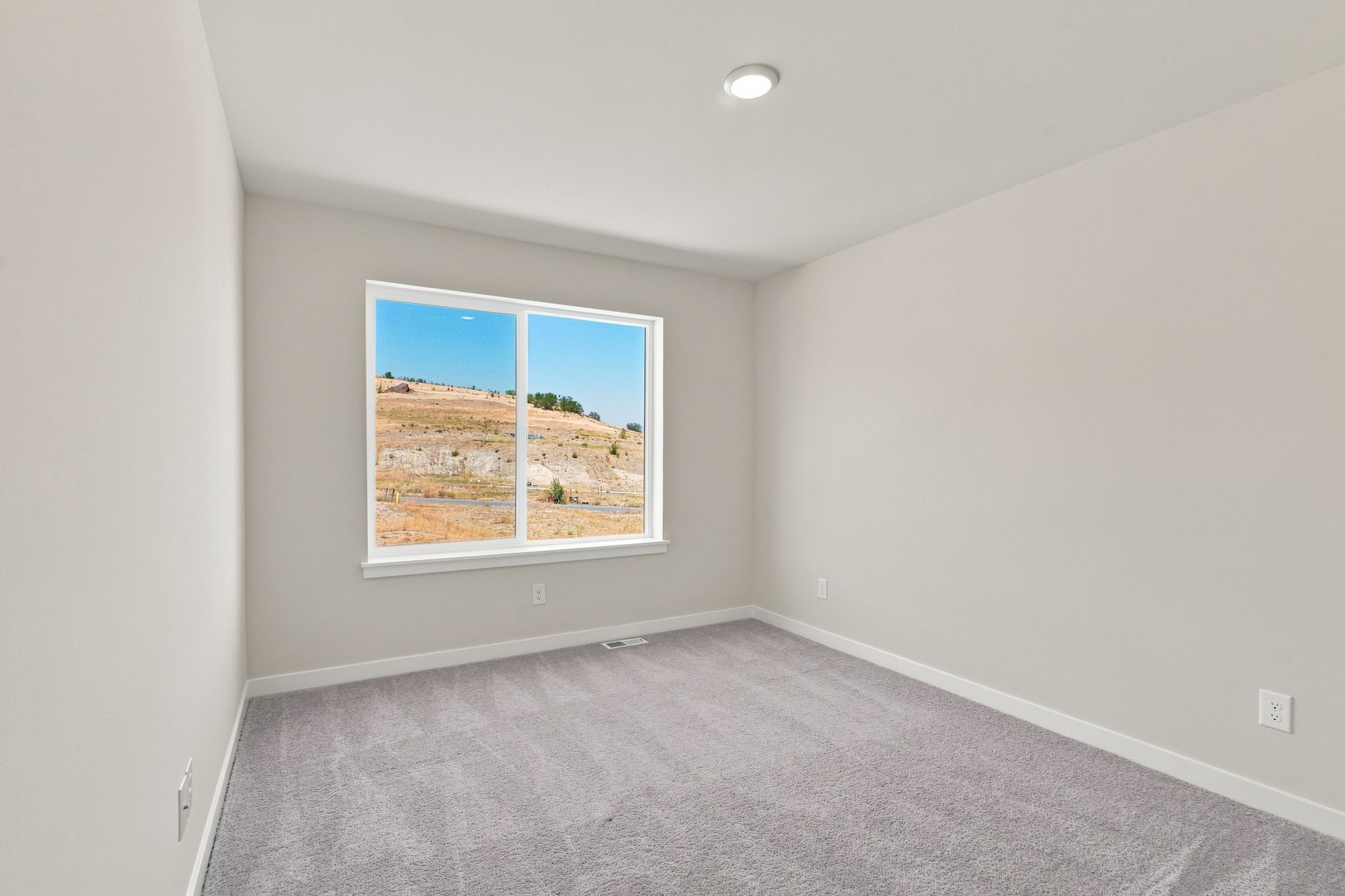 A room with a window and a carpet.
