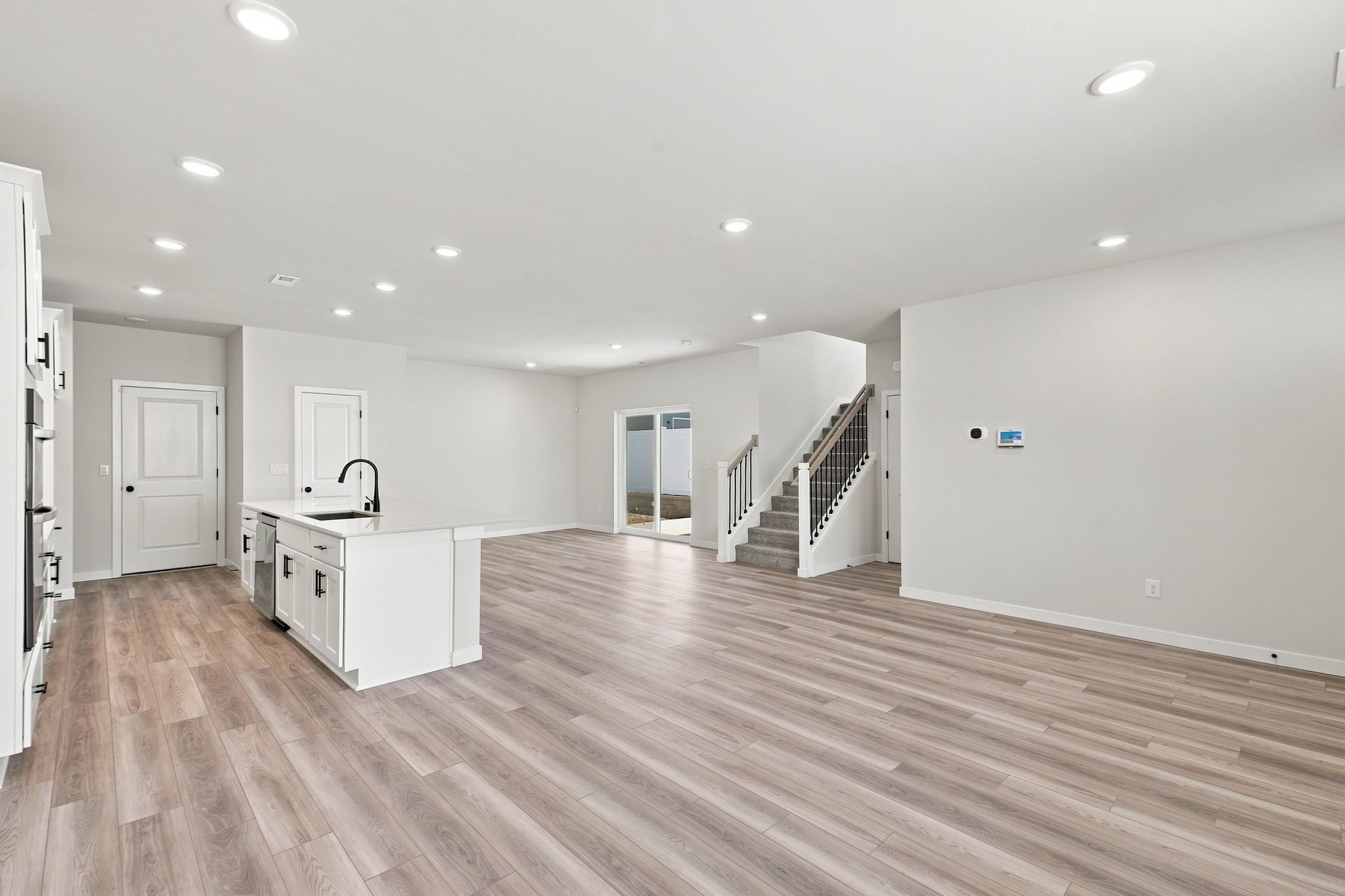 A large empty room with a wood floor and white walls.