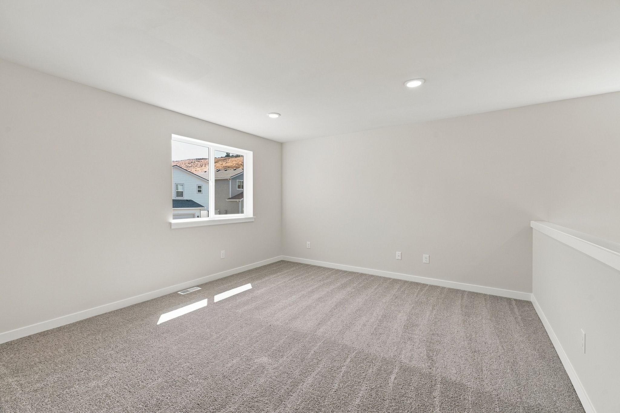A room with a window and carpet.