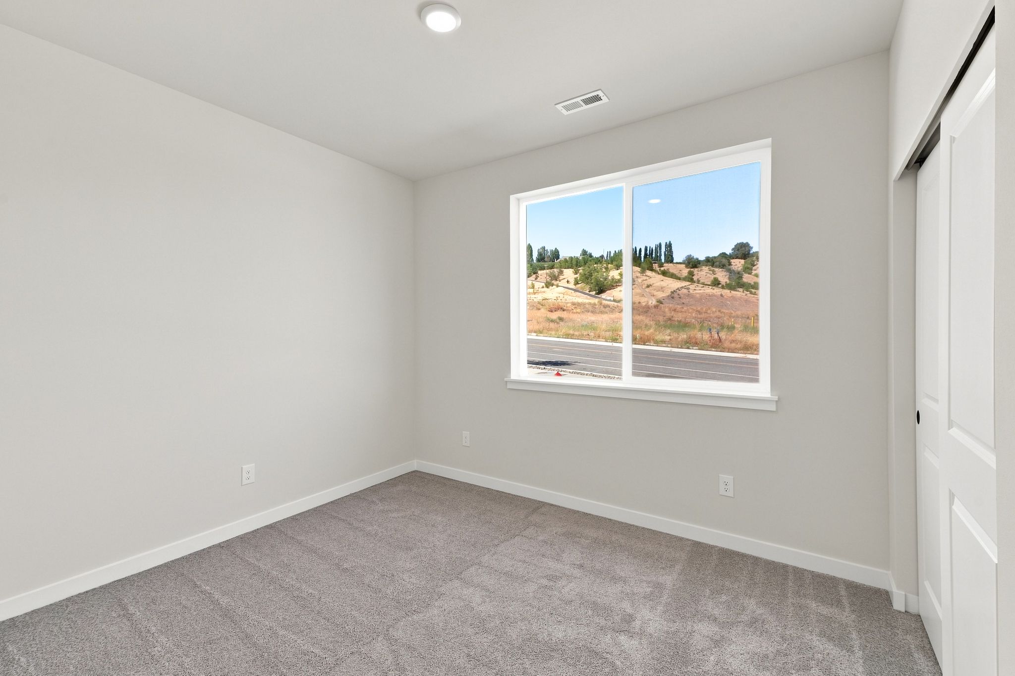 A room with a window and a carpet.