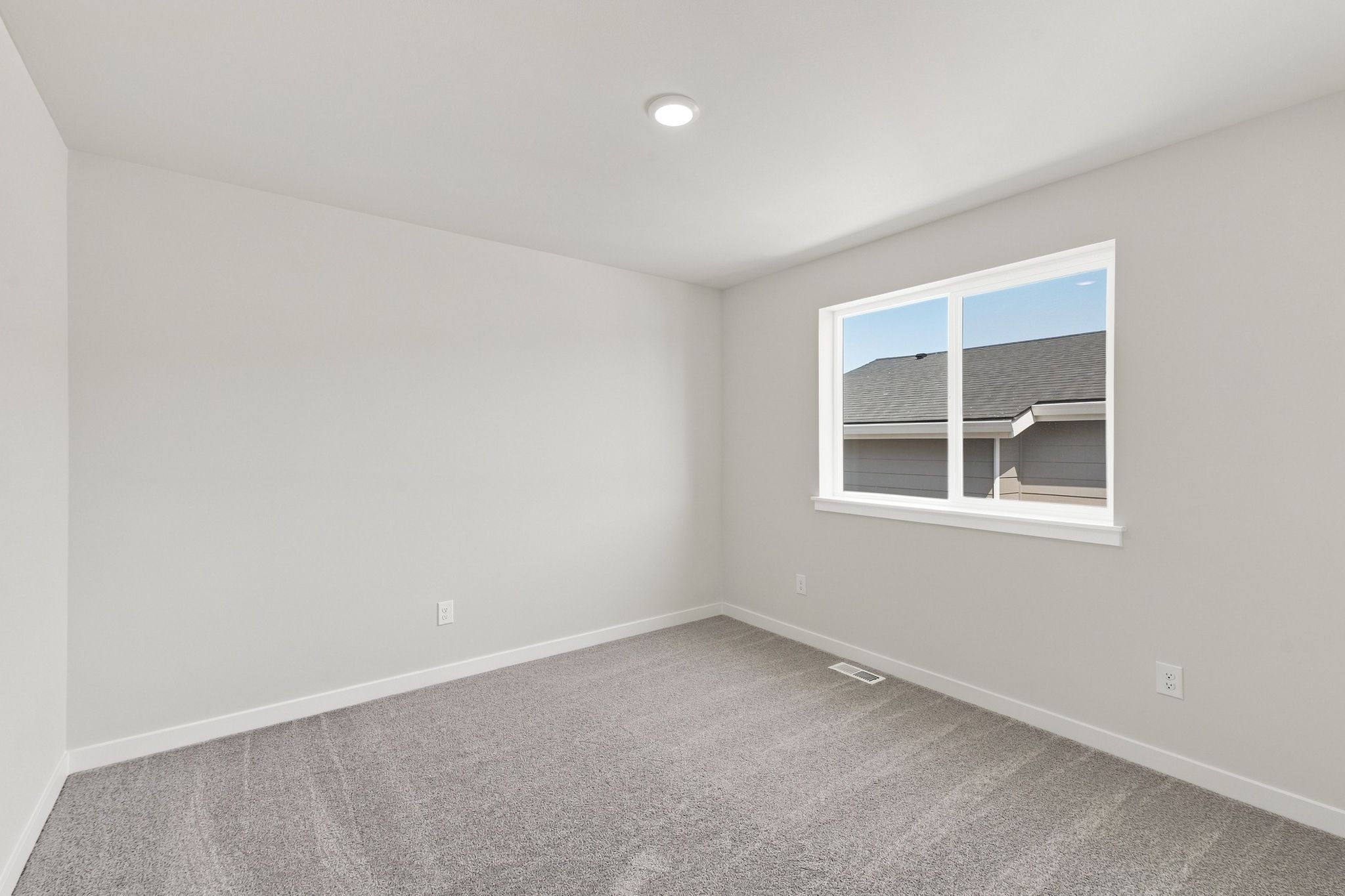 A room with a window and a carpet.
