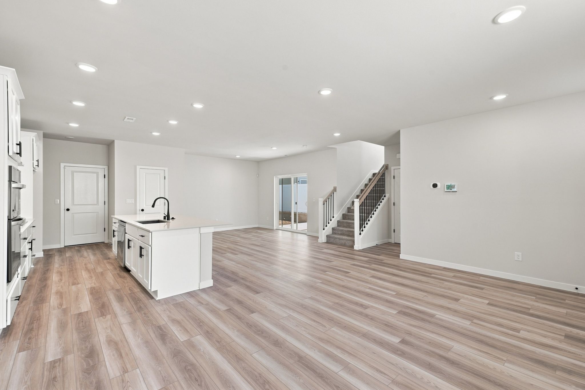 A large empty room with a wood floor and white walls.