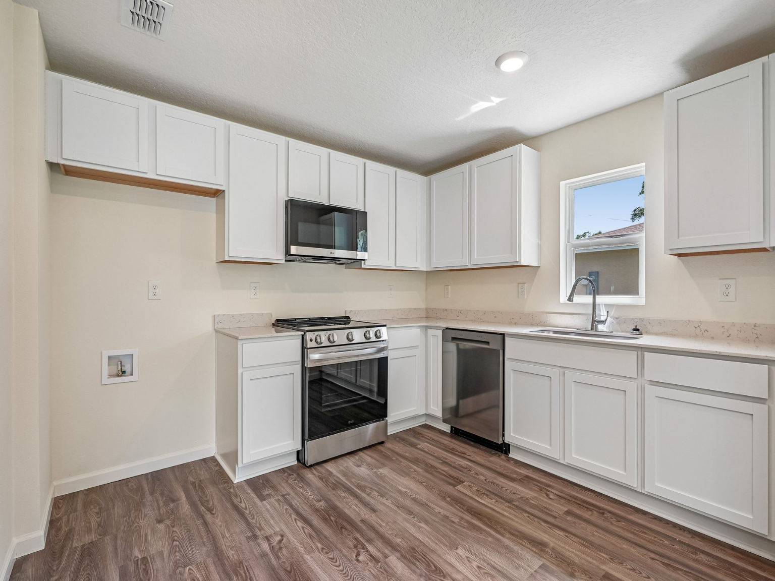 A kitchen with white cabinets.