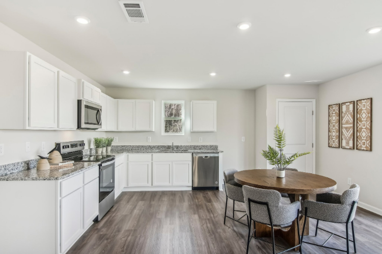 A kitchen with white cabinets.