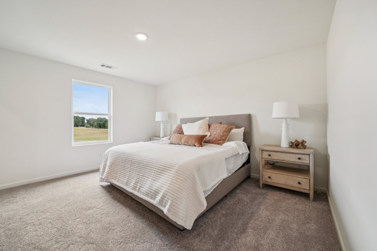 A bedroom with a bed and lamps.
