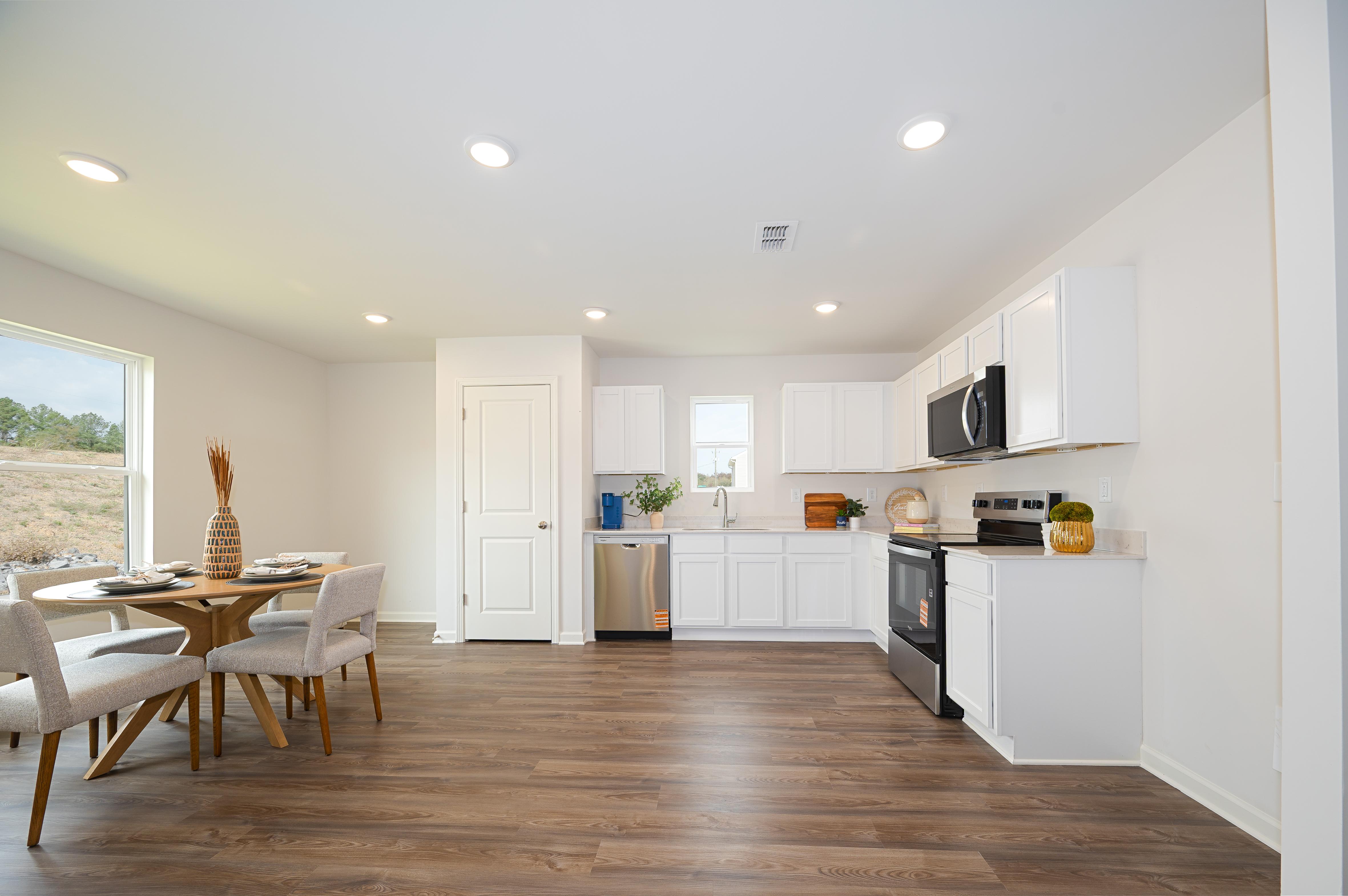 A kitchen with white cabinets.