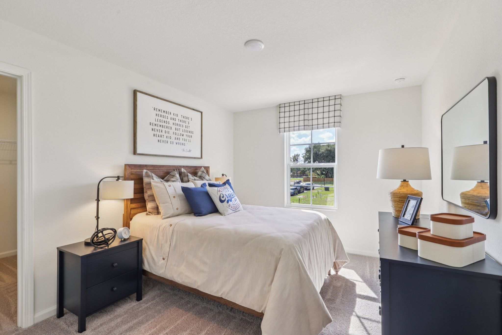 A bedroom with a bed and a mirror.