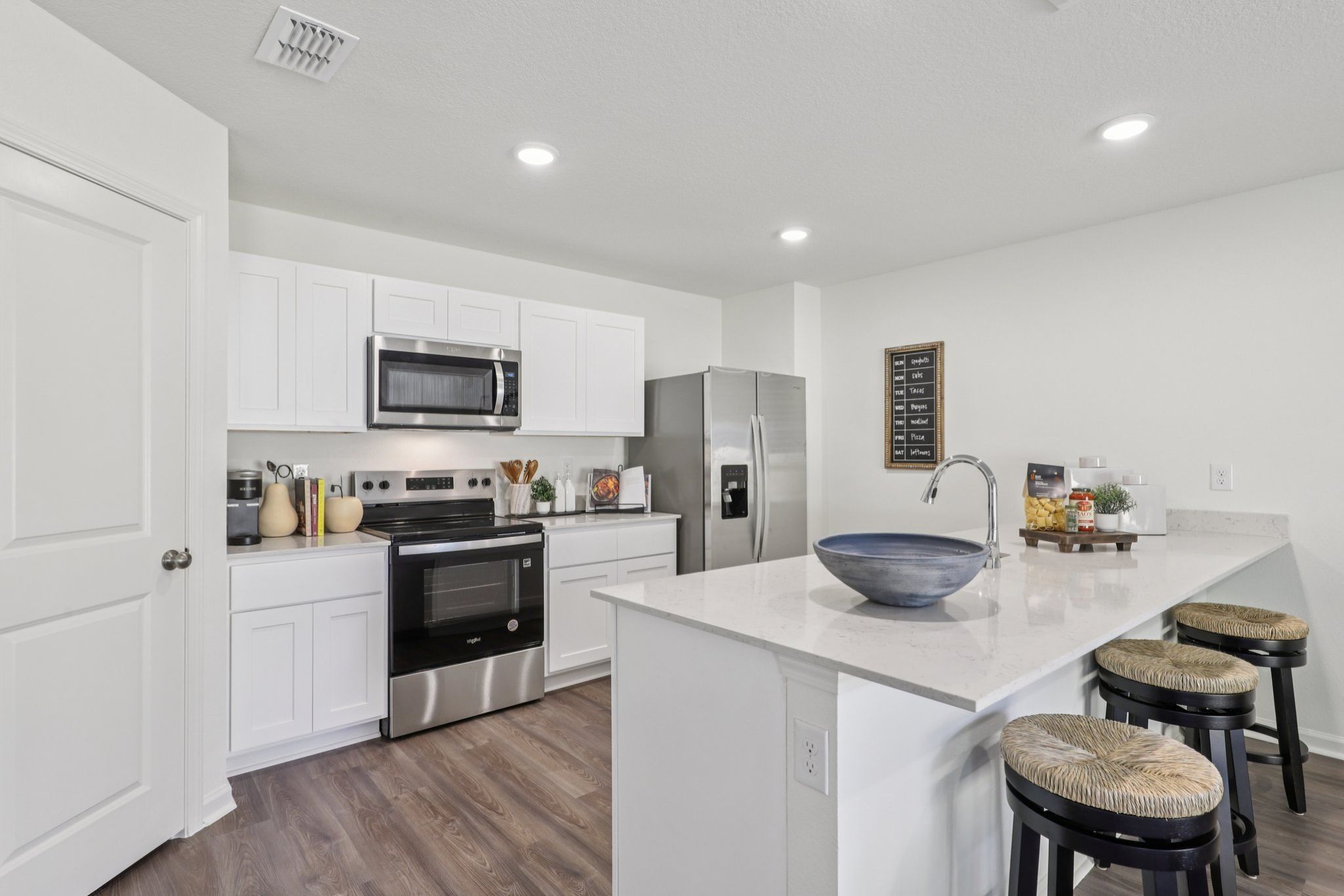 A kitchen with white cabinets.