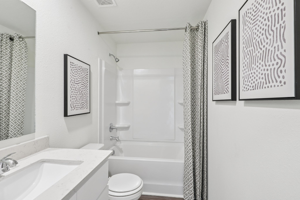 A bathroom with a shower and sink.